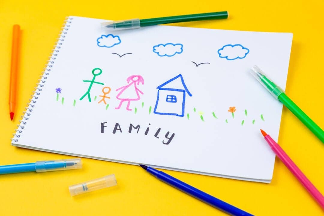 Parent and child drawing together at a table